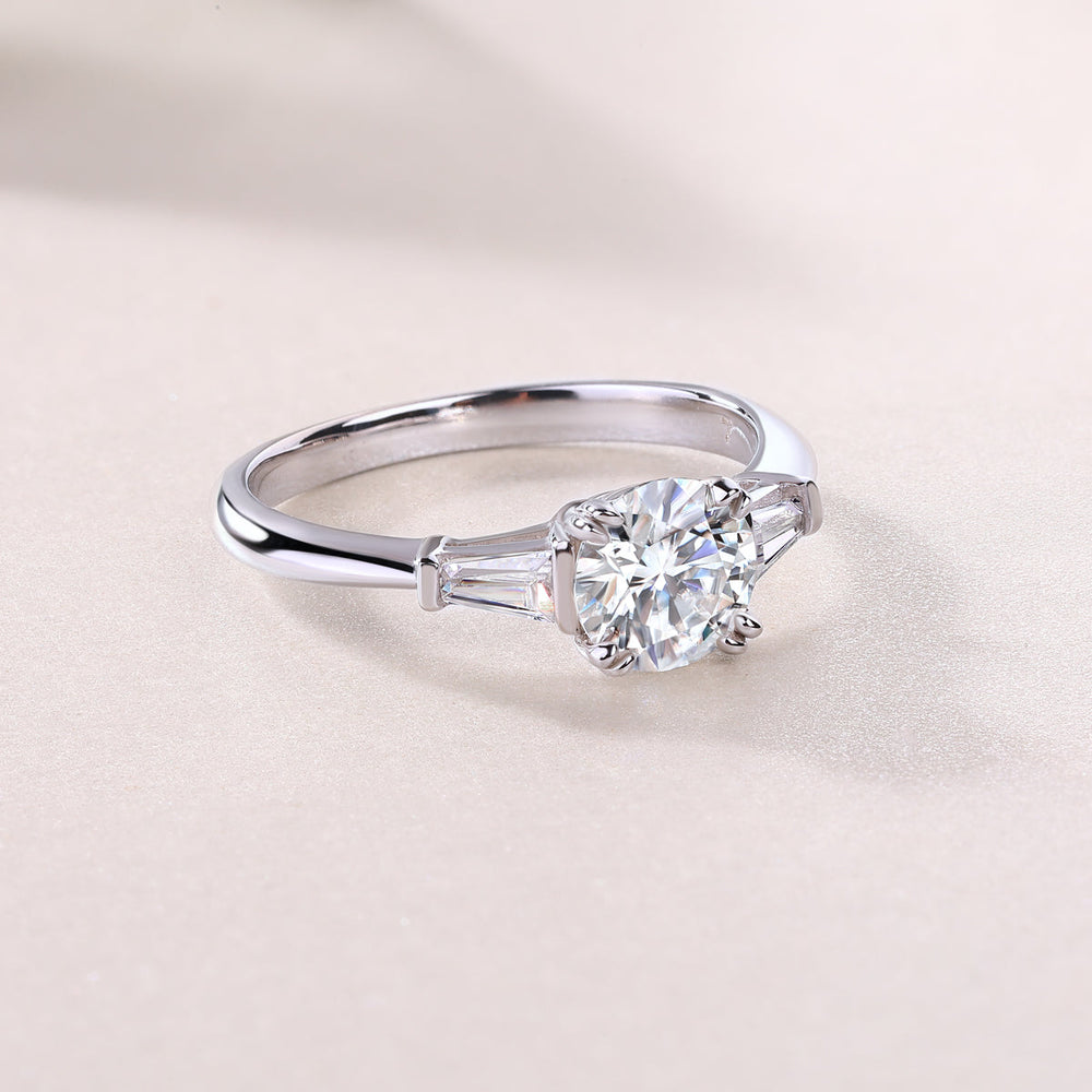 White metal three-stone engagement ring, round center with baguette side settings