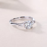 White metal three-stone engagement ring, round center with baguette side settings