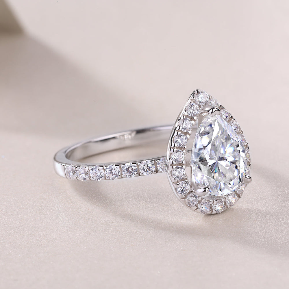 Pear-cut halo engagement ring profile with full pavé band, white gold vermeil