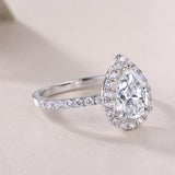 Pear-cut halo engagement ring profile with full pavé band, white gold vermeil