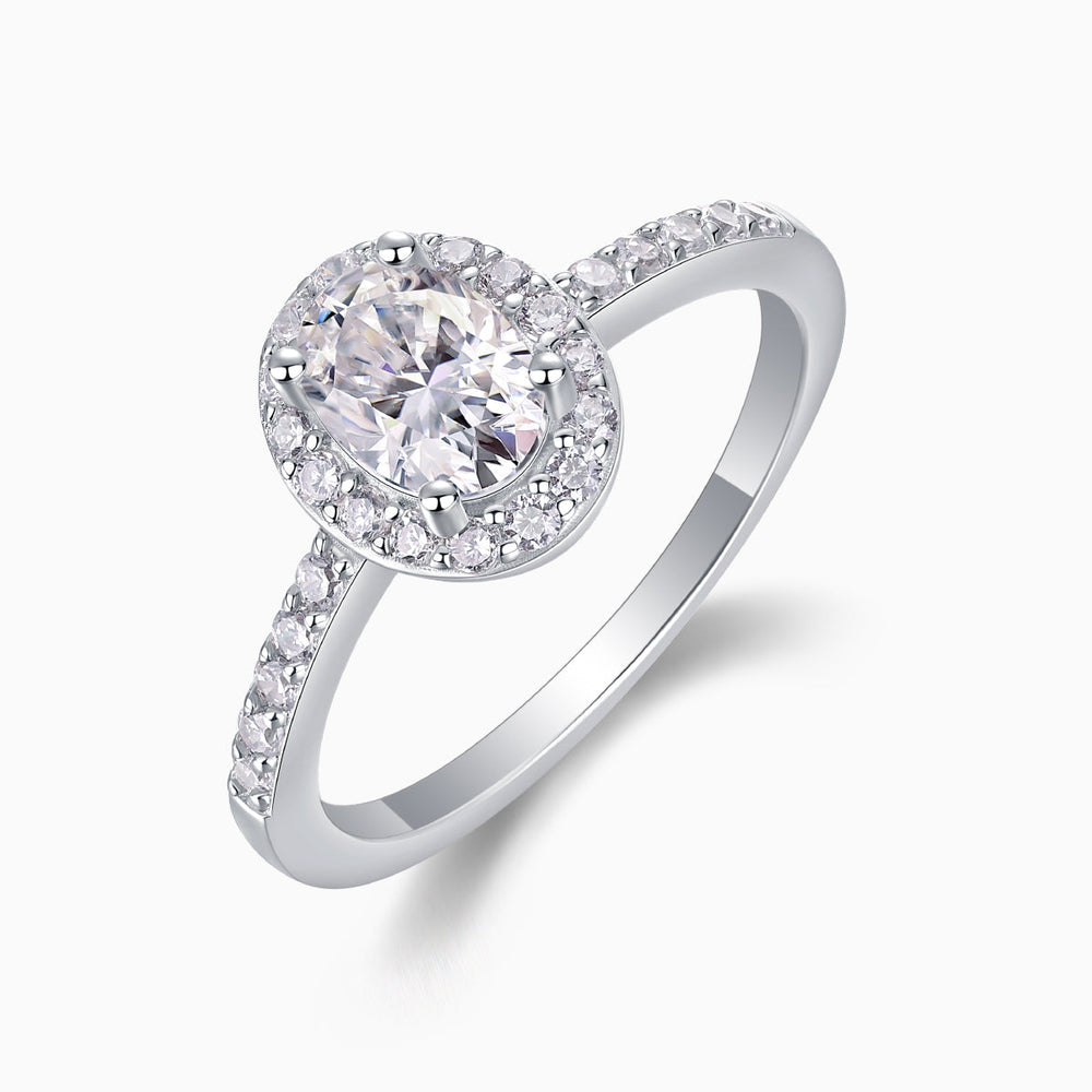 Angled view of oval Moissanite pavé halo engagement ring, white gold vermeil