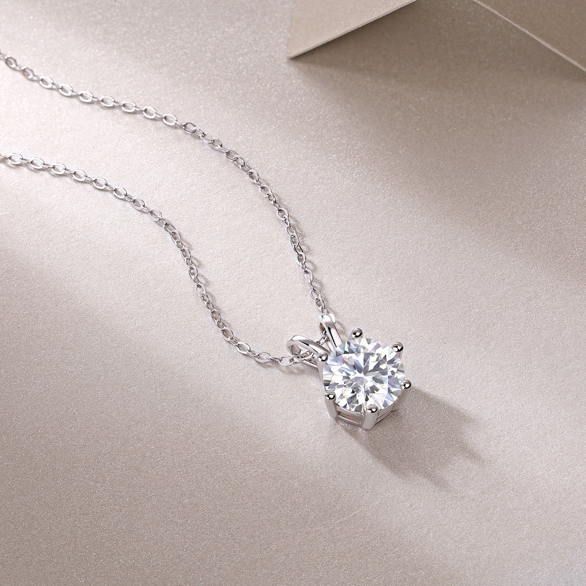 Round moissanite pendant in 6-prong crown setting on chain, white gold vermeil