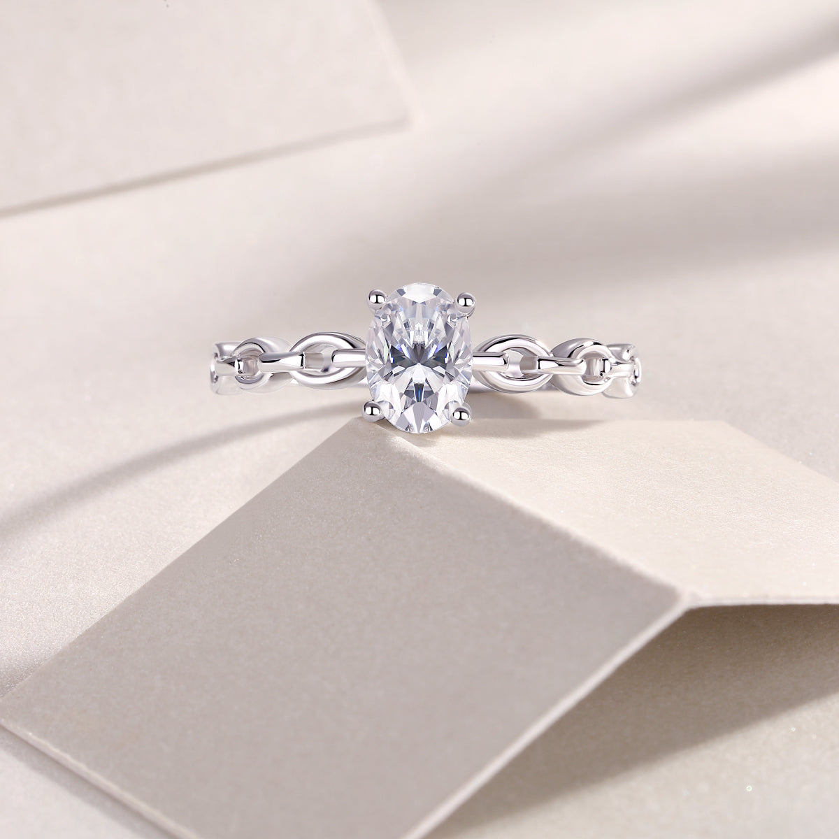 Oval moissanite chain link band ring with prong-set oval center stone, white gold