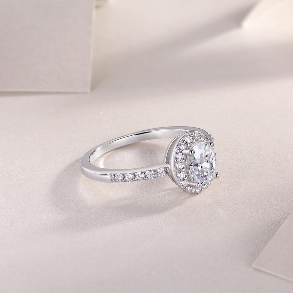 Three-quarter view of oval Moissanite pavé engagement ring, white gold vermeil