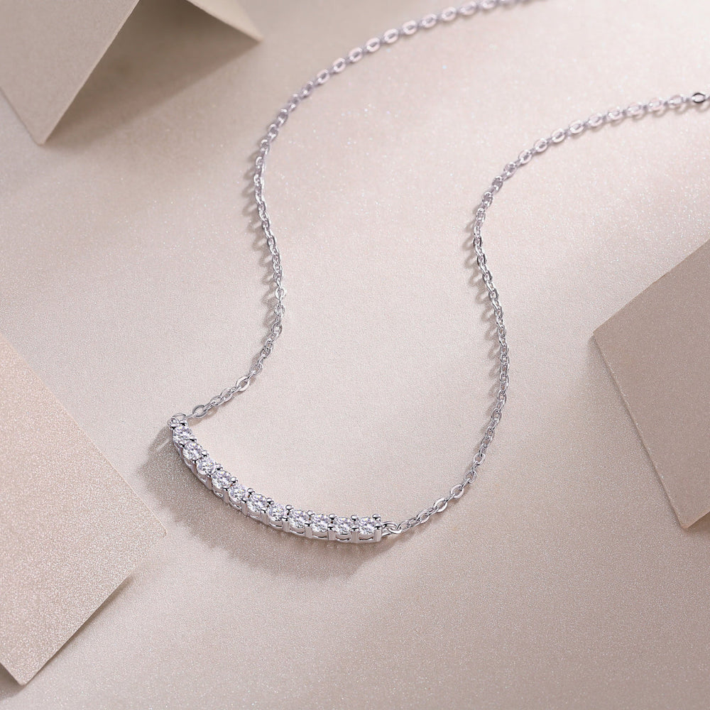 Curved bar moissanite smile necklace close-up with evenly spaced round stones