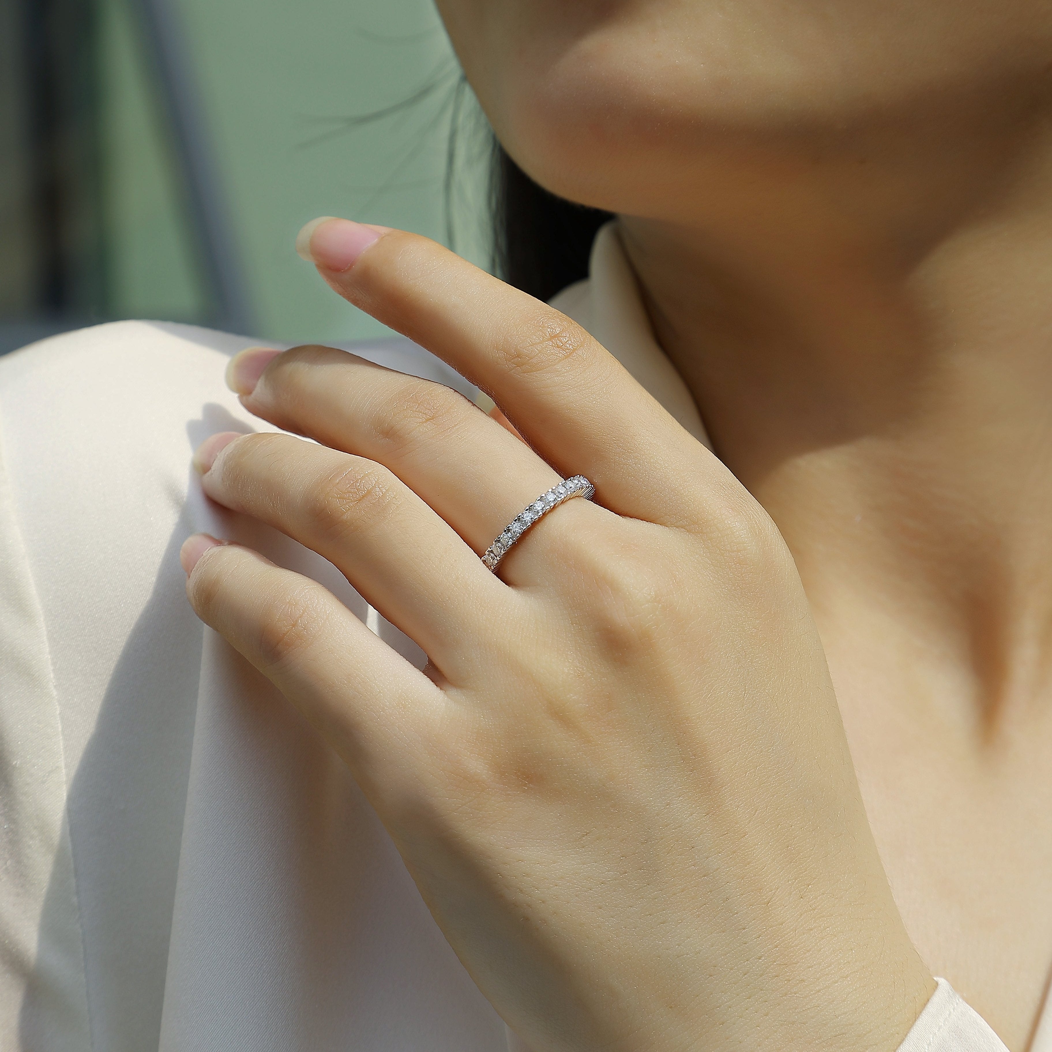 Silver moissanite pavé stacking ring on finger, tight band with small round stones