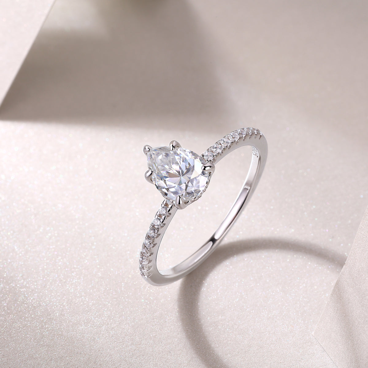 Pear cut pavé moissanite ring, prong-set pear center with curved pavé shank