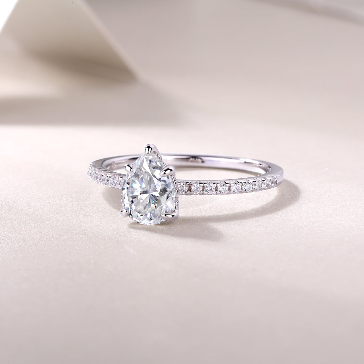 Pear cut pavé moissanite engagement ring, slender pavé band with pear center prongs