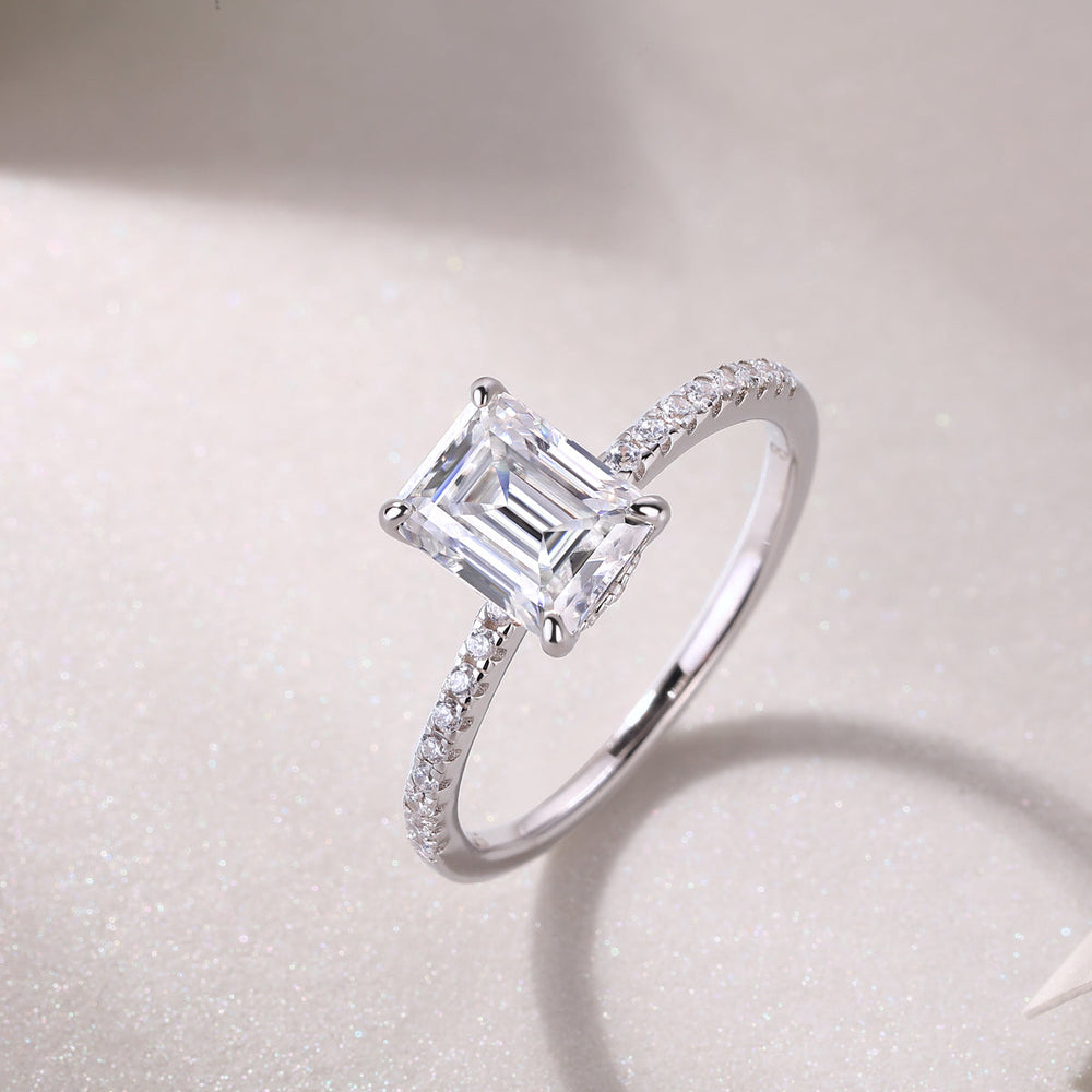 Emerald-cut moissanite ring with pavé band and claw prongs, white gold vermeil