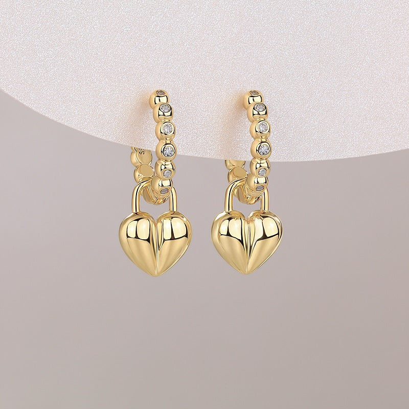 Pair of yellow gold vermeil heart charm earrings on beaded huggie bands