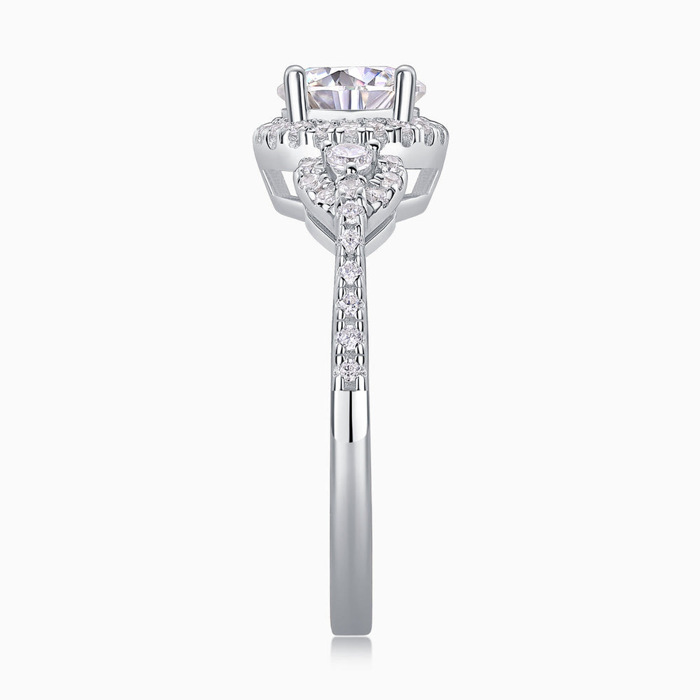 Front view of round halo moissanite ring with pear side stones on a slim band