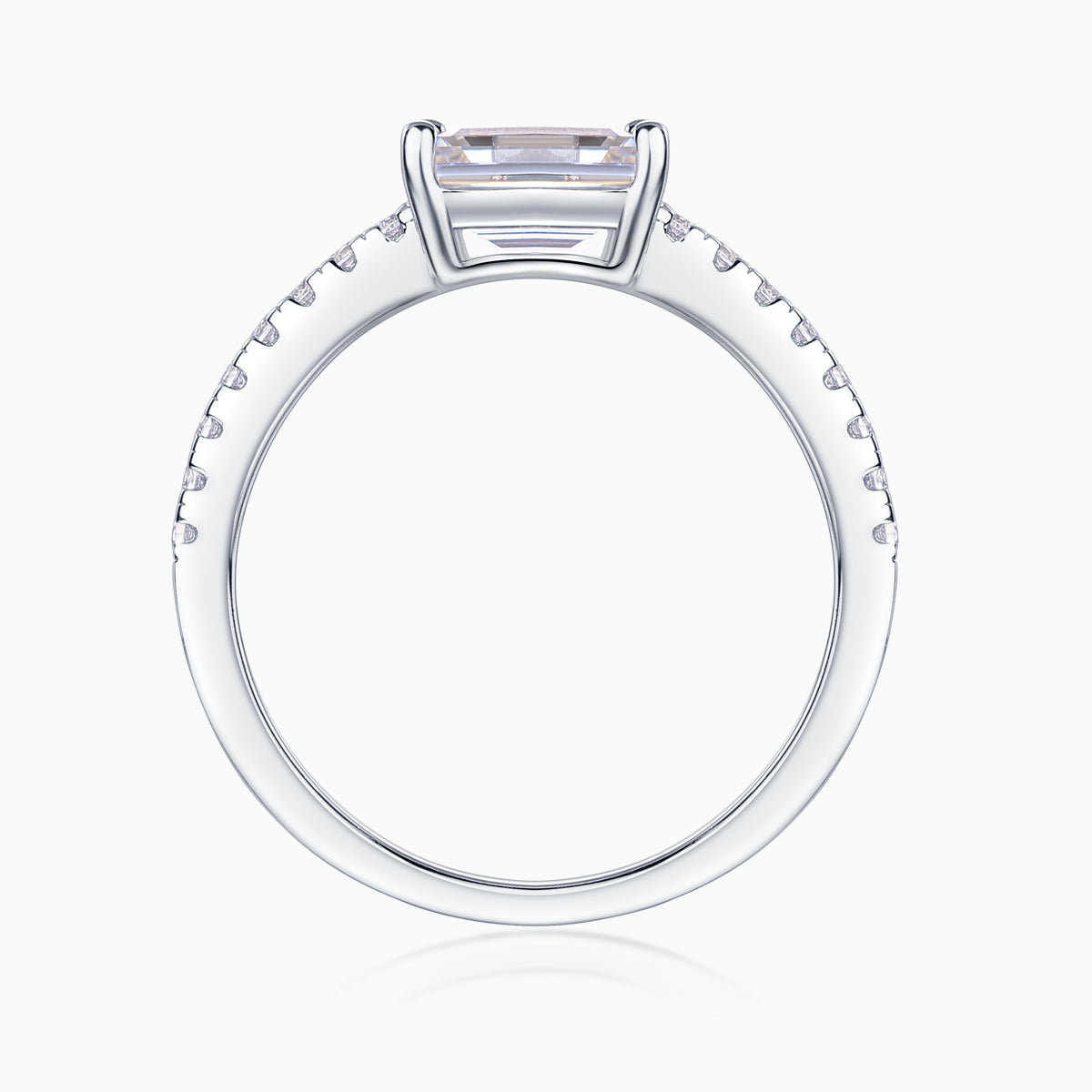 Top view of emerald-cut moissanite ring with pavé shoulders, white gold tone