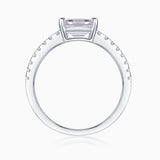 Top view of emerald-cut moissanite ring with pavé shoulders, white gold tone