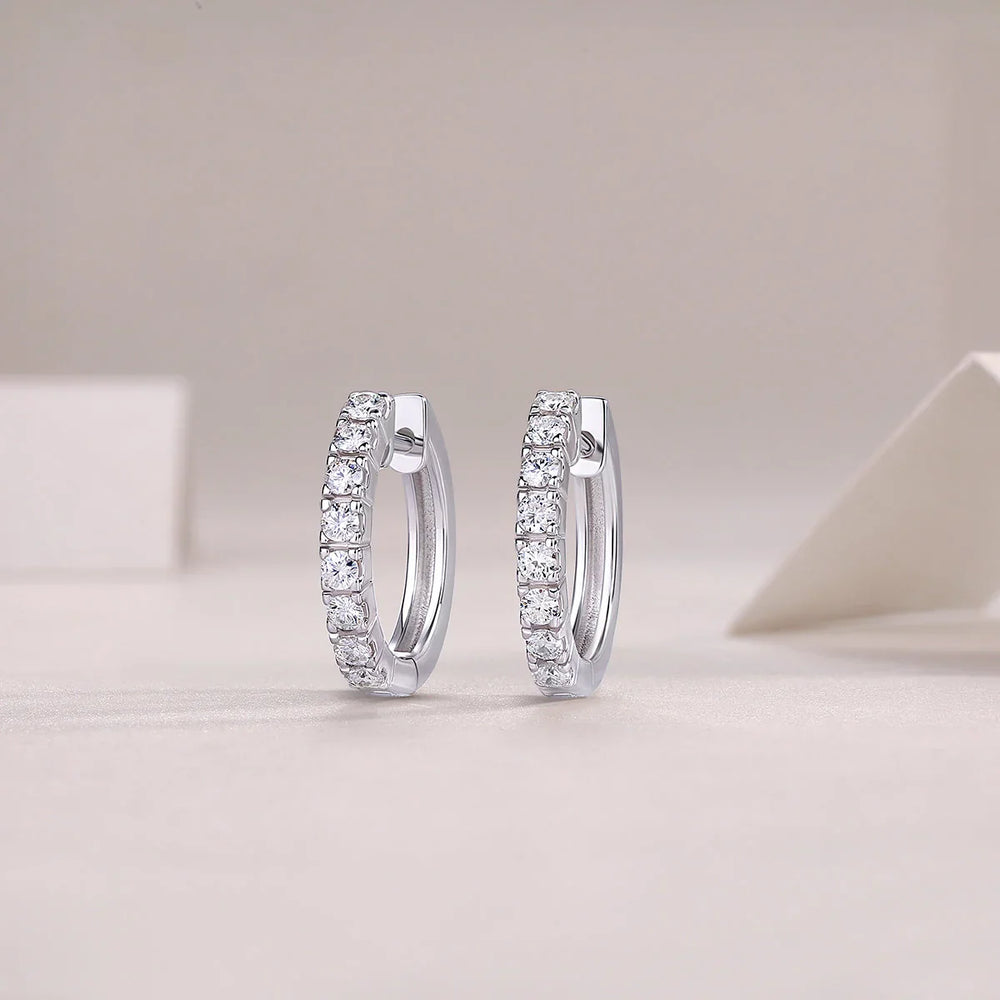 Single-row moissanite huggie hoops with shared prong bezel, bright stone row