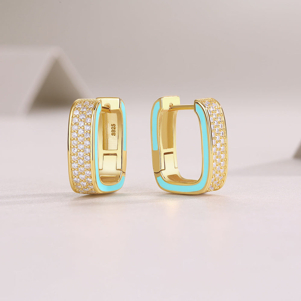 Side view of triple-row square pavé huggie earrings; yellow gold vermeil, blue inner detail