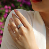 3-piece stackable ring set on finger with round center moissanite and pavé bands