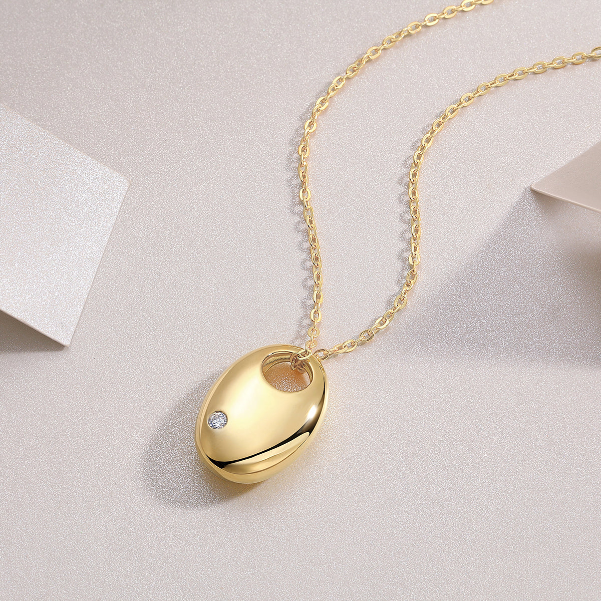 Oval dome pendant necklace with yellow gold tone finish and small round moissanite stone