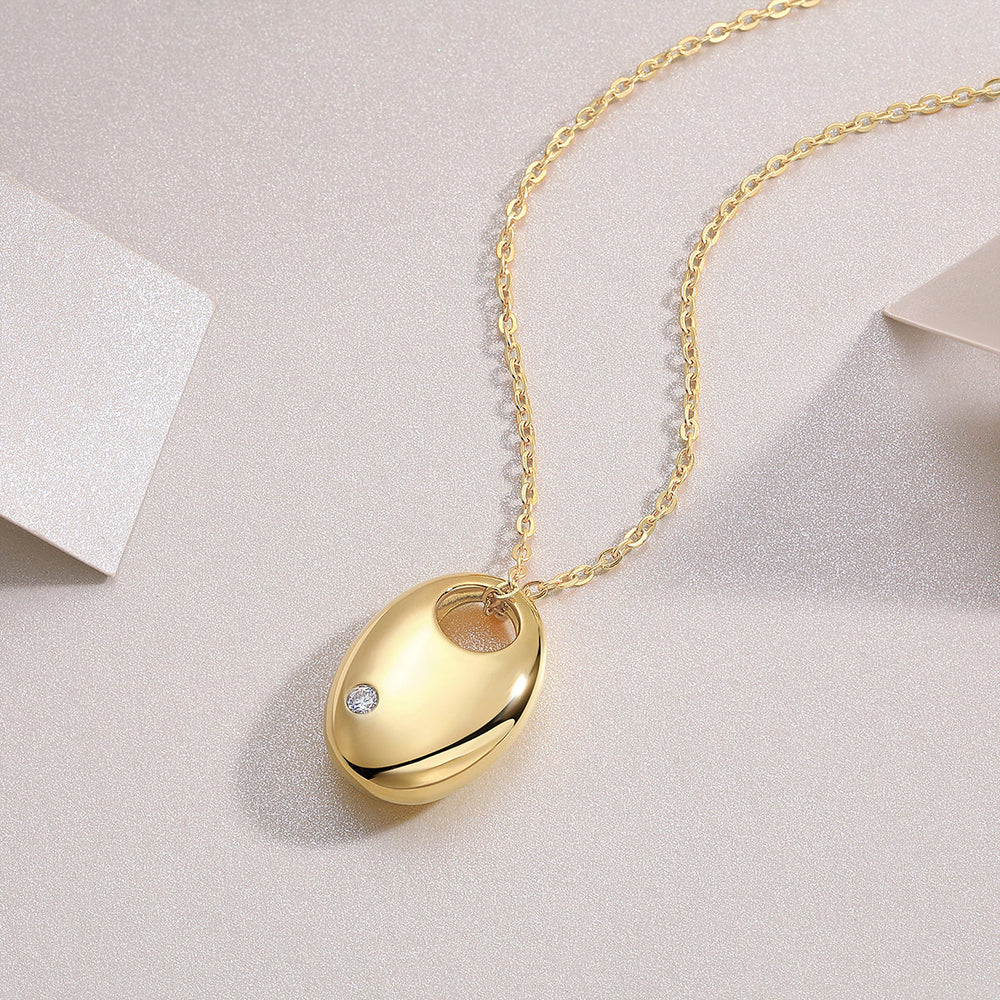 Oval dome pendant necklace with yellow gold tone finish and small round moissanite stone