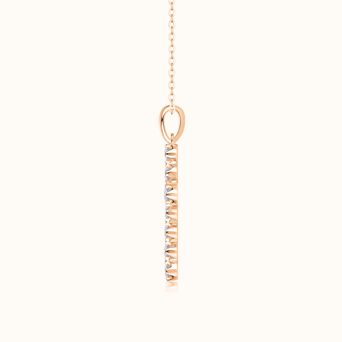 Rose gold cross pendant on link chain with oval bail and vertical stone-set front