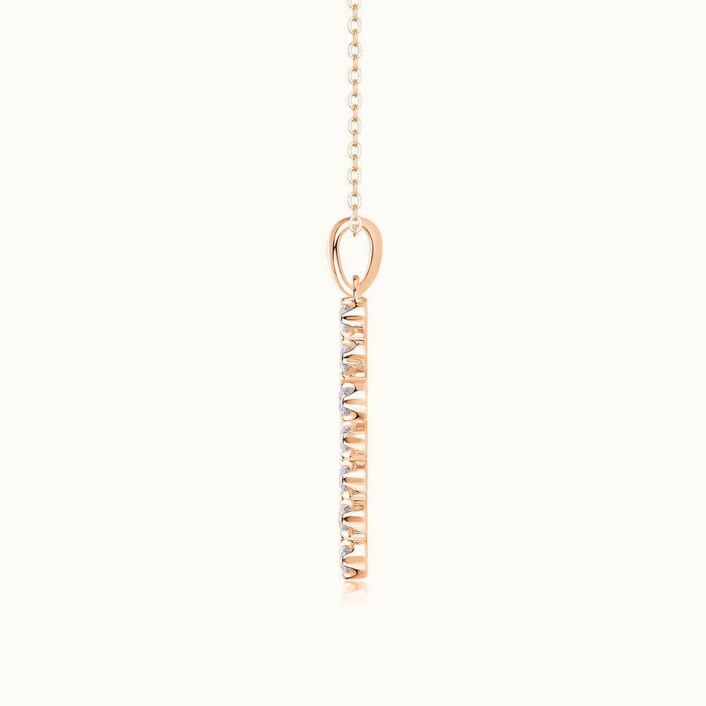 Rose gold cross pendant on link chain with oval bail and vertical stone-set front