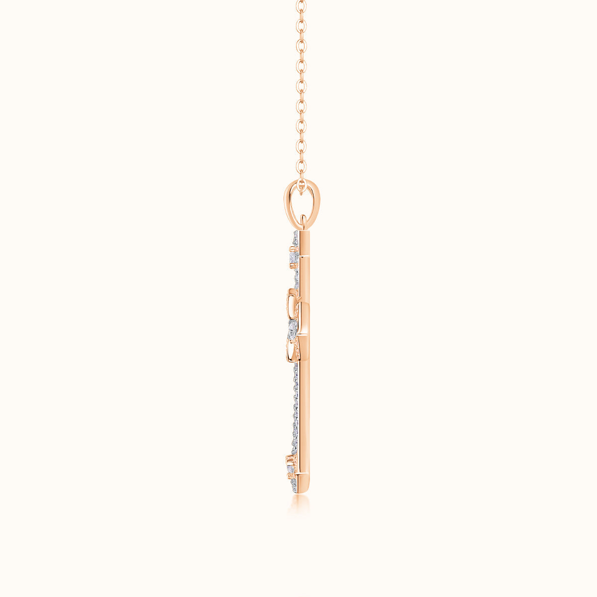 Rose gold tone cross pendant back view with bail and chain links, pavé details