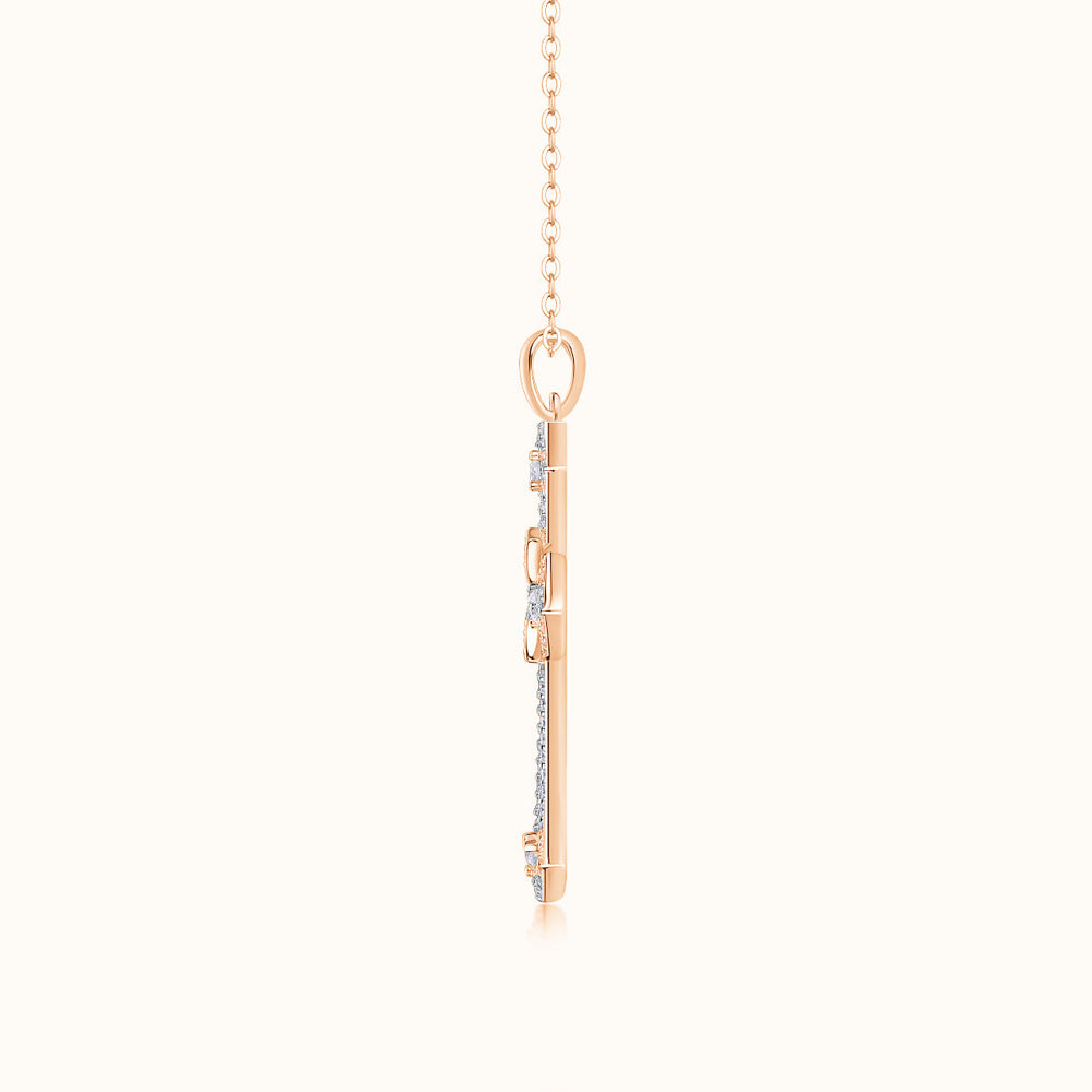 Rose gold tone cross pendant back view with bail and chain links, pavé details