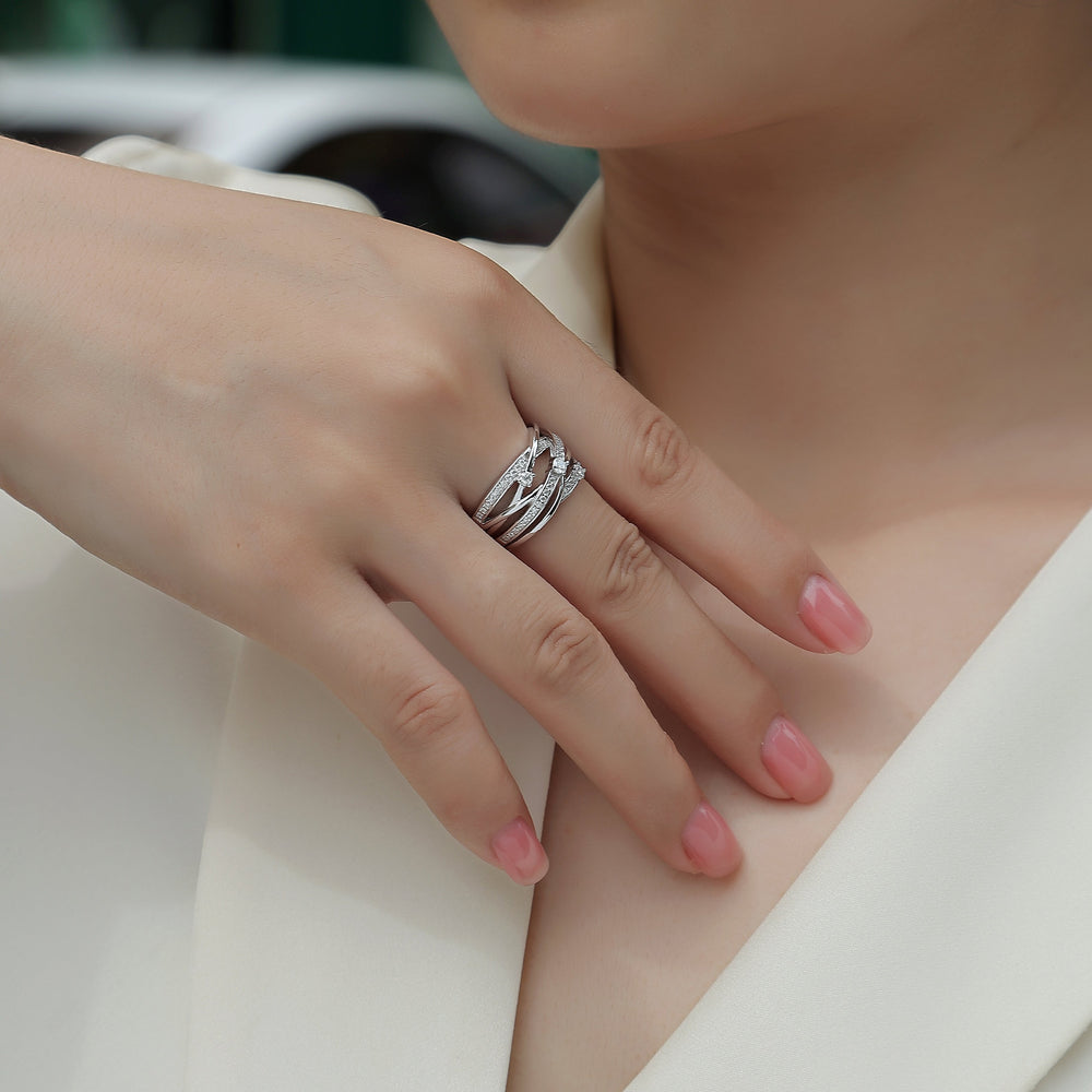 Crossover wide band ring with round moissanite centerpiece on finger, pavé detail