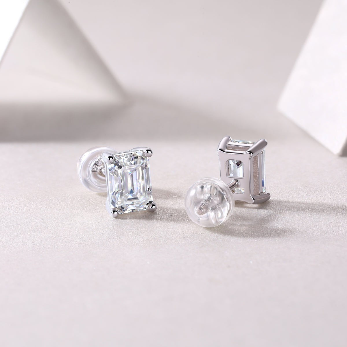Emerald cut moissanite studs, side view; clear stone in white gold vermeil