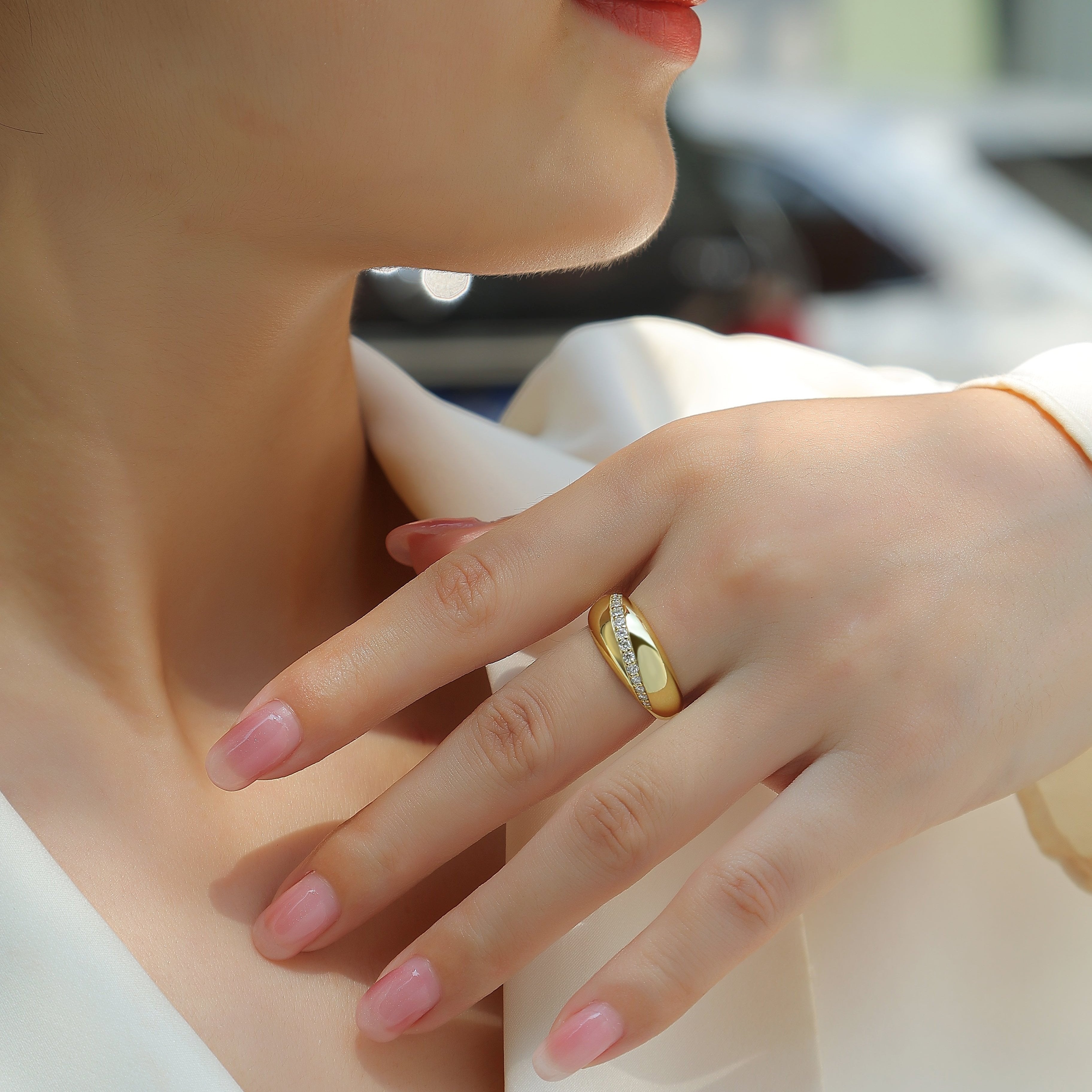 Moissanite dome band ring on hand, yellow gold vermeil with white stones and black swoosh