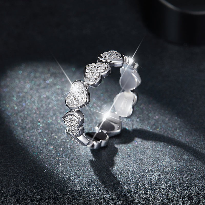 Side view: heart moissanite ring with six raised heart settings, white gold vermeil