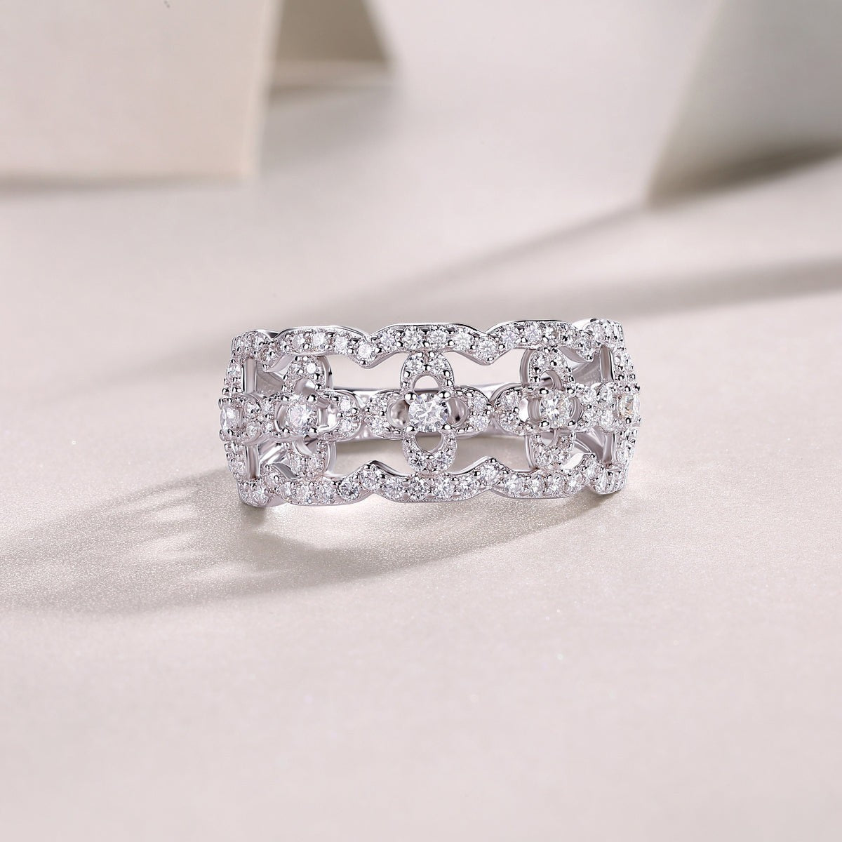 Hollow-cut moissanite band ring with repeating oval settings and pavé stones