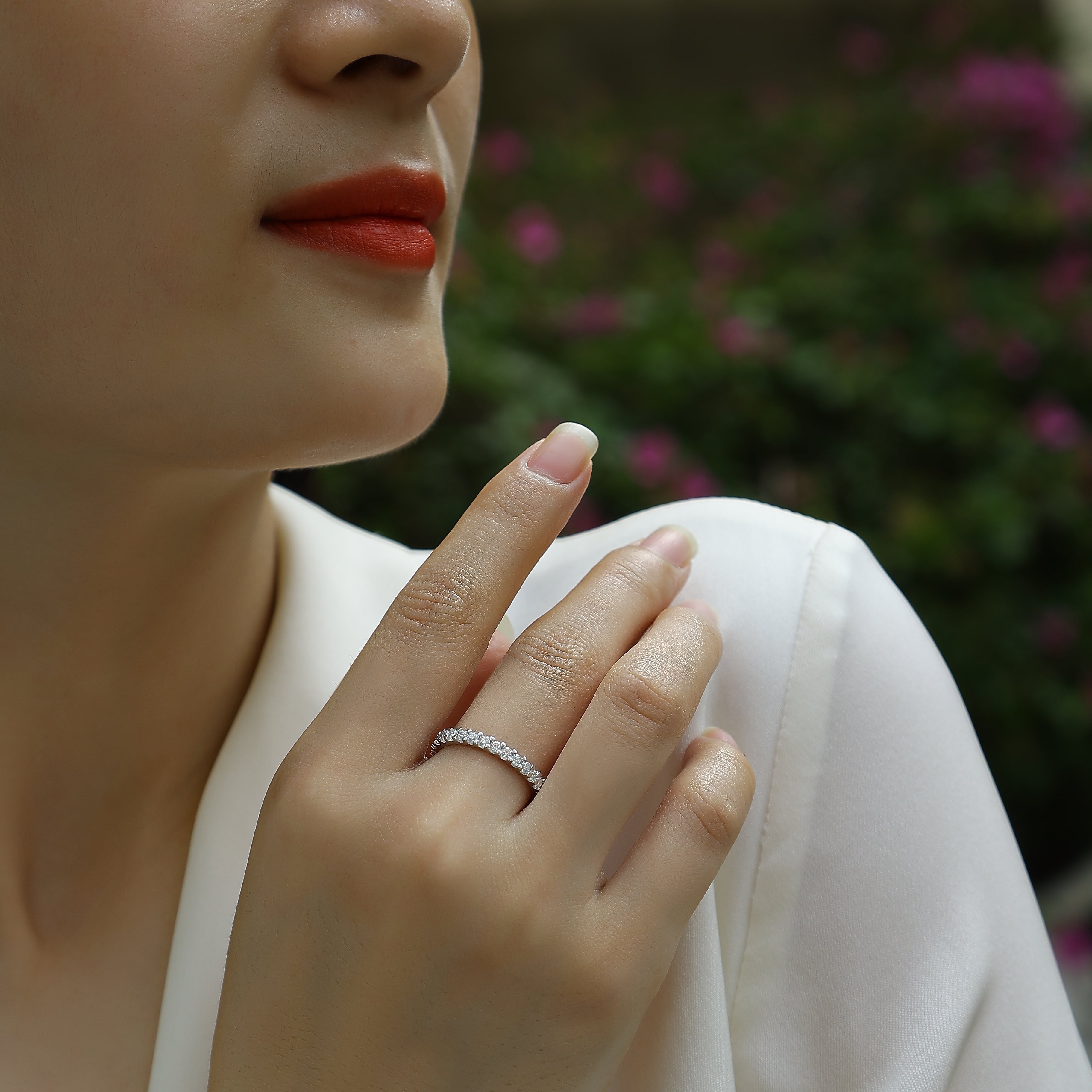 Moissanite pavé eternity band on finger, white-gold look with round stone sparkle row