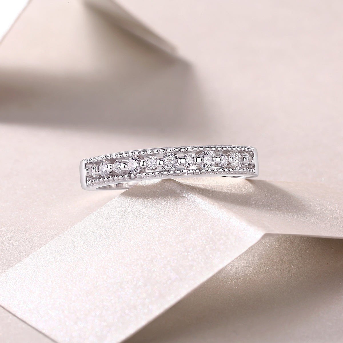 White gold vermeil moissanite half pavé band with raised round-stone settings