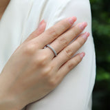 Pavé moissanite wedding band with a continuous row of round stones on finger