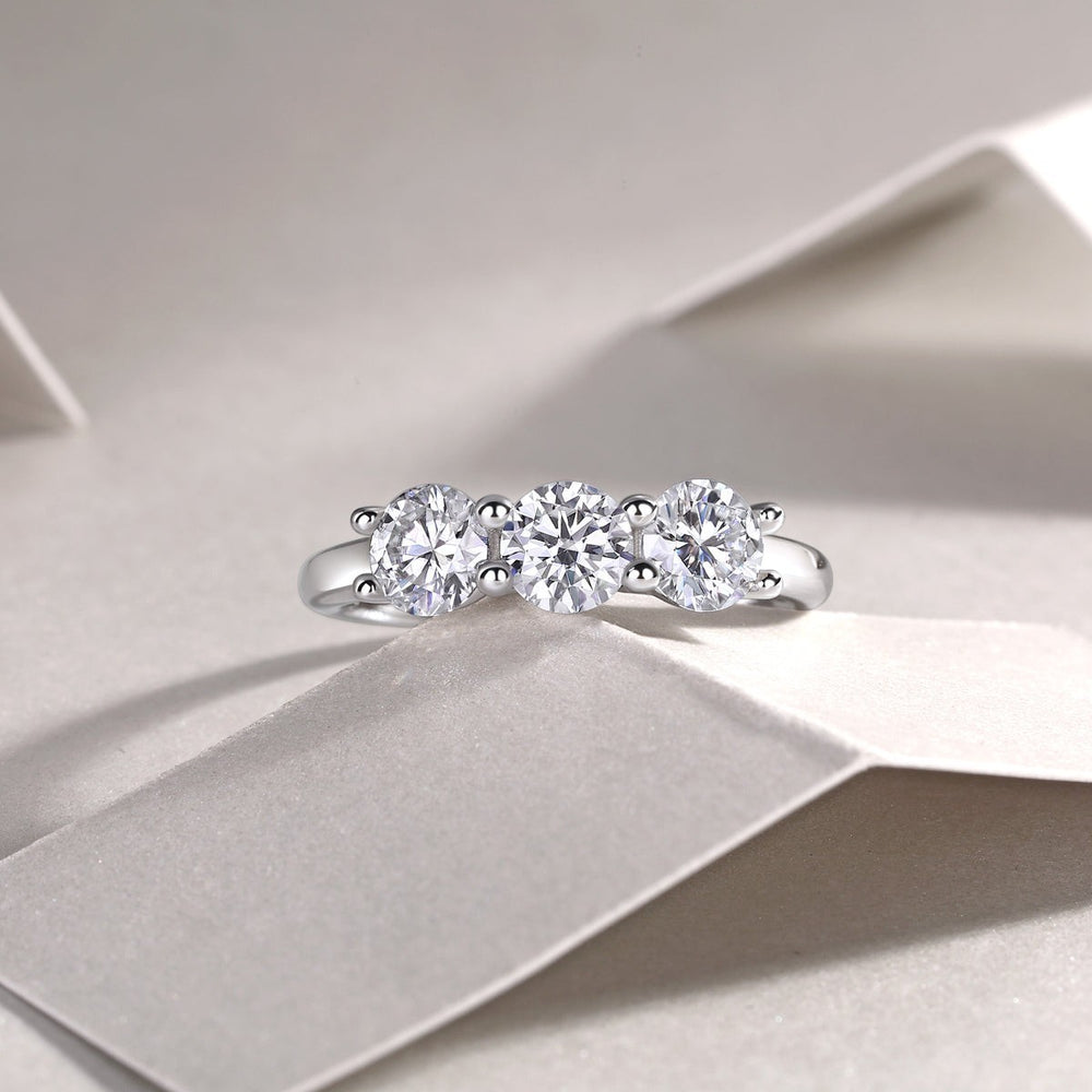 Three-stone moissanite wedding band with three round stones and prong settings