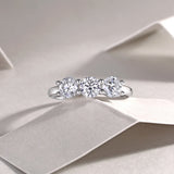 Three-stone moissanite wedding band with three round stones and prong settings