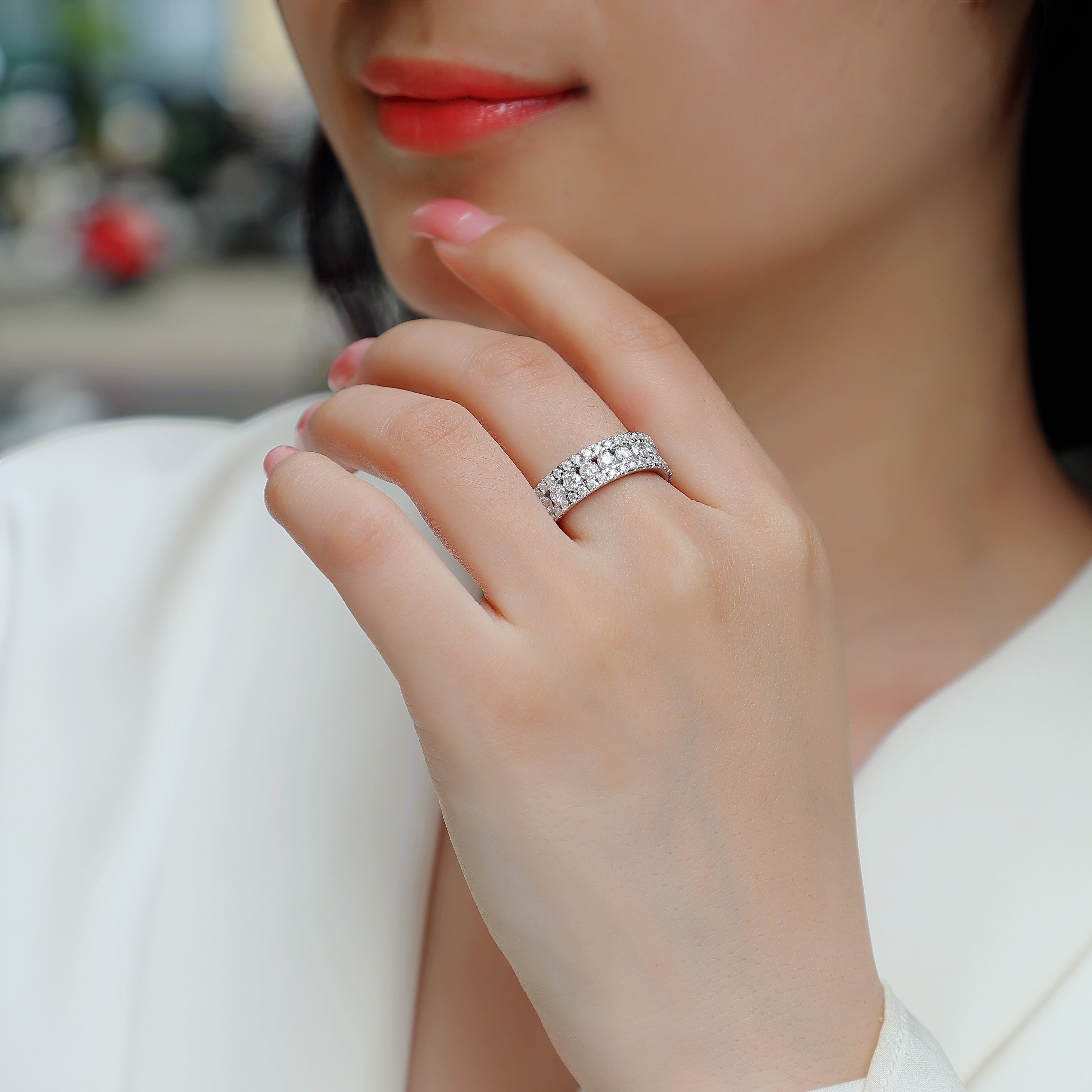 Triple-row pavé moissanite ring on hand, small round stones in three rows, white metal