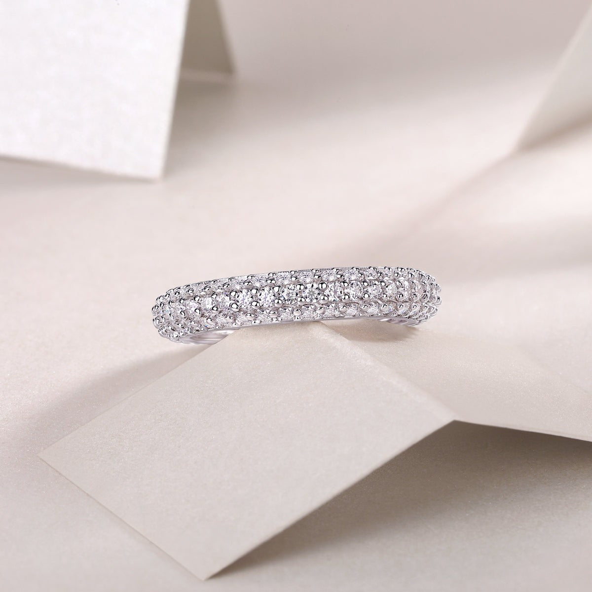 Triple-row pavé moissanite band ring, profile view with dense sparkle stones.