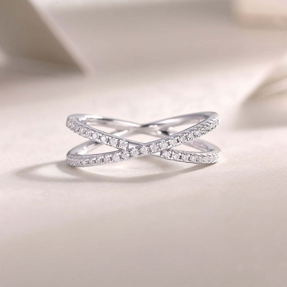 X-Cross Moissanite pavé band with X design and sparkling clear stones on white metal