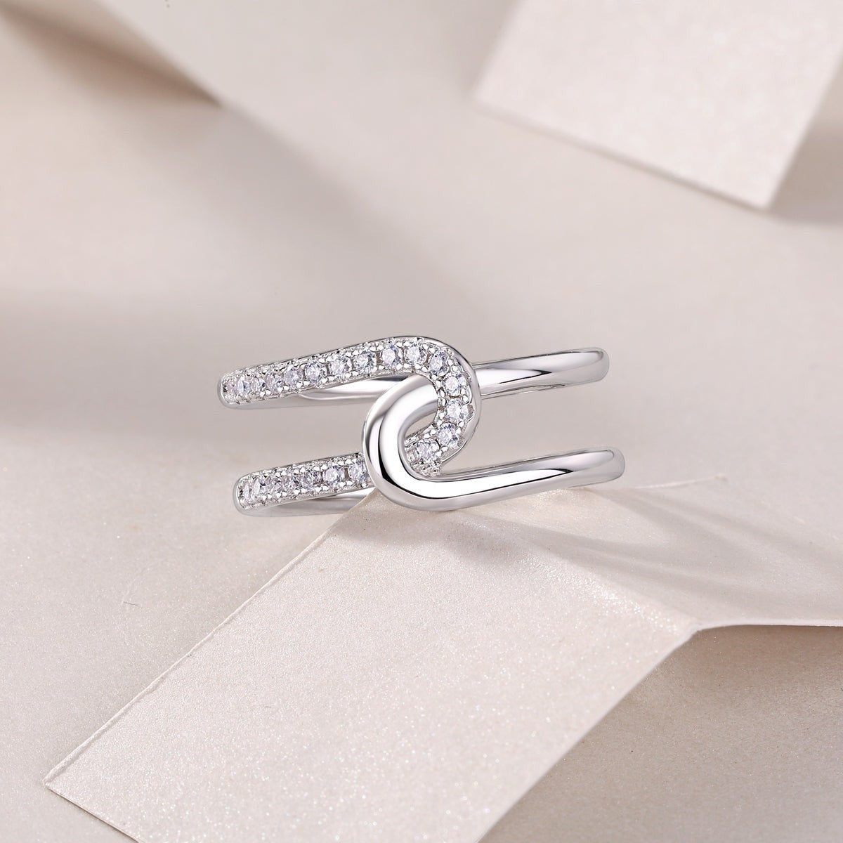White gold tone wide band moissanite ring with oval halo detail and pavé