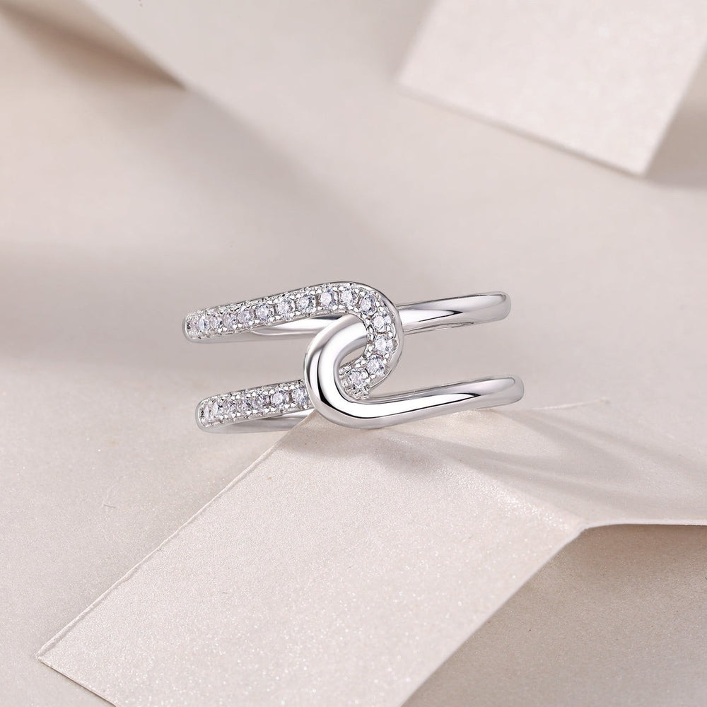 White gold tone wide band moissanite ring with oval halo detail and pavé