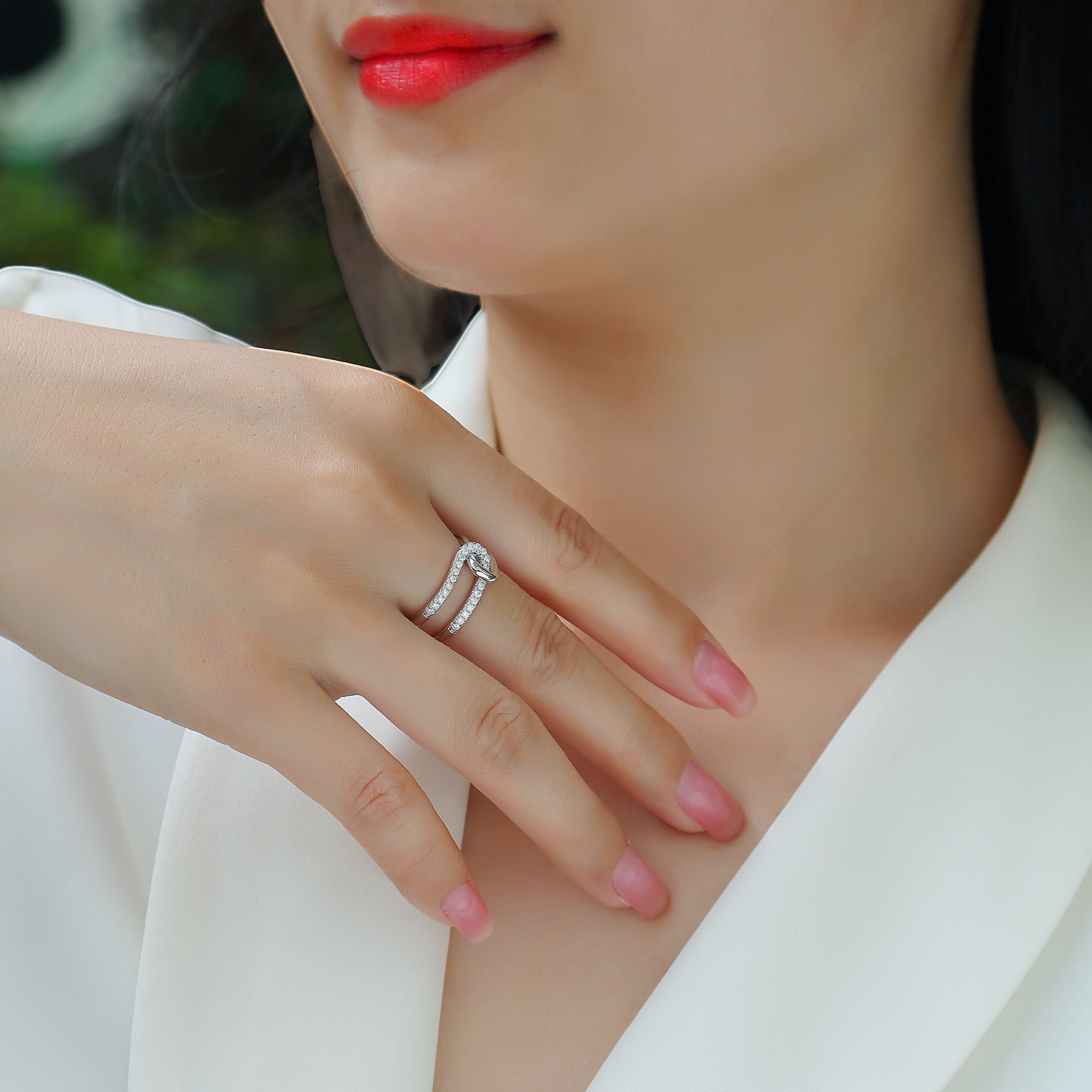 White gold tone wide band ring with pavé stones, worn on hand