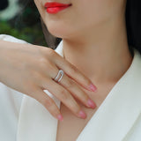 White gold tone wide band ring with pavé stones, worn on hand